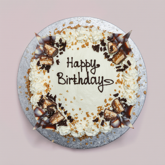Birthday cake with whipped cream, chocolate pieces, and 'Happy Birthday' text on a pink background