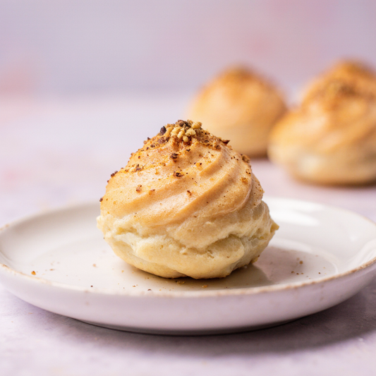 Fresh pistachio profiteroles topped with crushed pistachios from The Happy Family Bakery