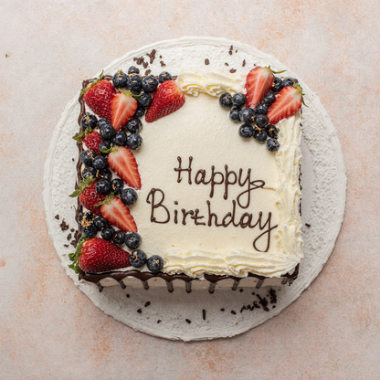 Birthday cake with strawberries and blueberries on a light background